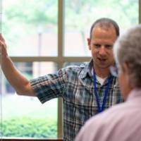 Teacher explains tree fencing to attendees at student project showcase